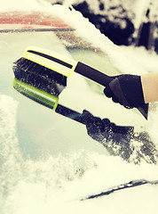 Image showing closeup of man cleaning snow from car