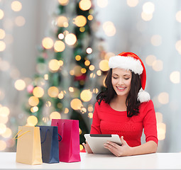 Image showing smiling woman with shopping bags and tablet pc