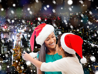 Image showing happy mother and girl in santa hats