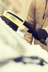 Image showing closeup of man cleaning snow from car