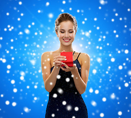 Image showing smiling woman holding red gift box