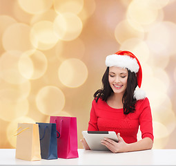 Image showing smiling woman with shopping bags and tablet pc