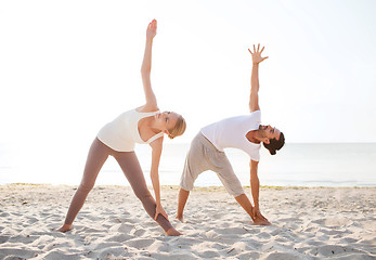 Image showing couple making yoga exercises outdoors