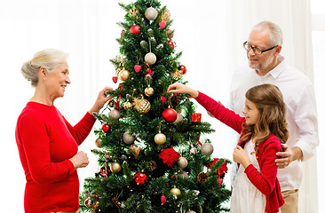 Image showing smiling family decorating christmas tree at home