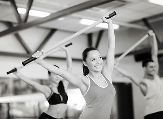 Image showing group of smiling people working out with barbells