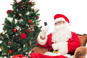 Image showing santa claus with smartphone and christmas tree