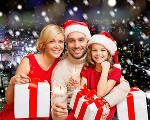 Image showing happy family in santa helper hats with gift boxes