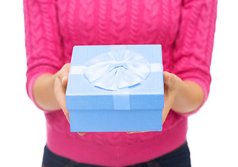 Image showing close up of woman in pink sweater holding gift box