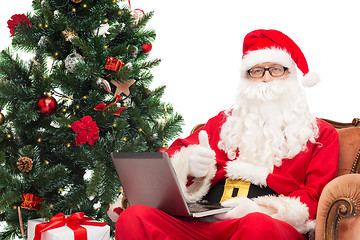 Image showing man in costume of santa claus with laptop