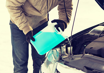 Image showing closeup of man pouring antifreeze into water tank