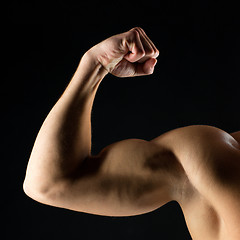 Image showing close up of young man showing biceps