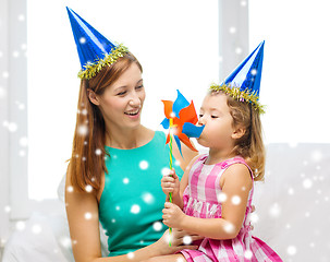 Image showing mother and daughter in party hats with pinwheel