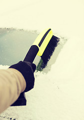 Image showing closeup of man cleaning snow from car