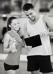 Image showing smiling male trainer with woman in the gym