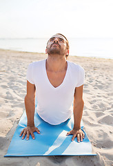 Image showing man doing yoga exercises outdoors