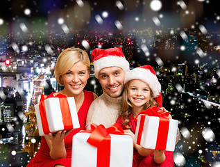 Image showing happy family in santa helper hats with gift boxes