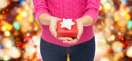 Image showing close up of woman in pink sweater holding gift box