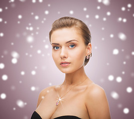 Image showing woman wearing shiny diamond earrings and pendant