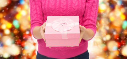 Image showing close up of woman in pink sweater holding gift box