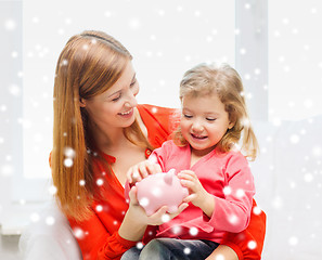 Image showing mother and daughter with piggy bank