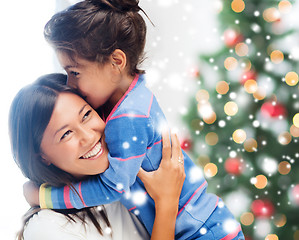 Image showing smiling little girl and mother hugging indoors