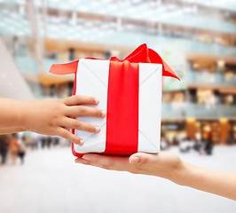 Image showing close up of child and mother hands with gift box