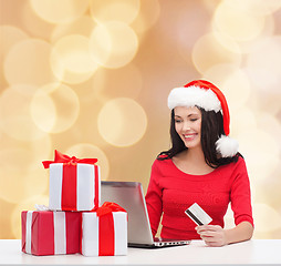 Image showing smiling woman with gifts, laptop and credit card