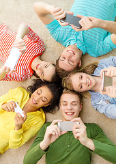 Image showing group of smiling people lying down on floor