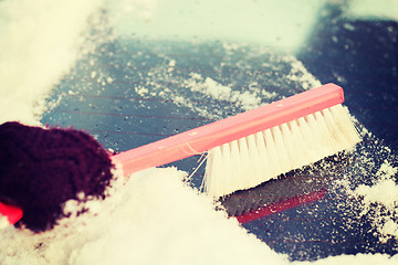 Image showing woman cleaning snow from car back window