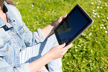 Image showing close up of girl with tablet pc sitting on grass