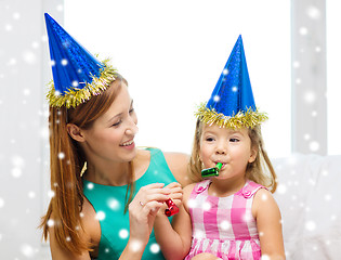 Image showing mother and daughter in party hats with favor horns