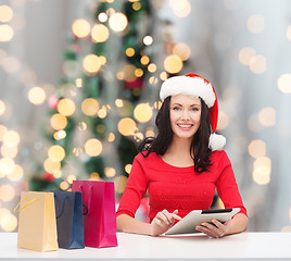 Image showing smiling woman with shopping bags and tablet pc