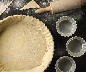 Image showing freshly maked dough in a baking tart form 