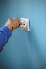 Image showing hand of a man fixing a socket cover
