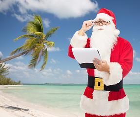 Image showing man in costume of santa claus with notepad