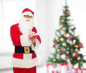 Image showing man in costume of santa claus with notepad