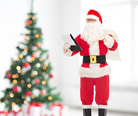 Image showing man in costume of santa claus with notepad and bag