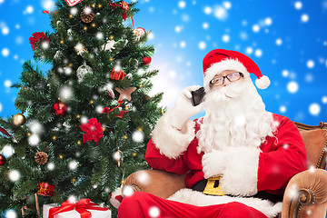 Image showing santa claus with smartphone and christmas tree