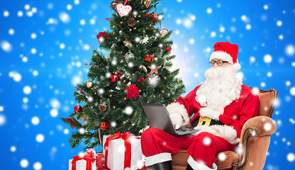 Image showing man in costume of santa claus with laptop