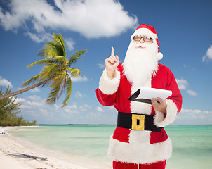 Image showing man in costume of santa claus with notepad