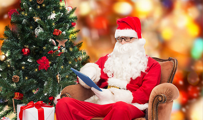 Image showing man in costume of santa claus with tablet pc