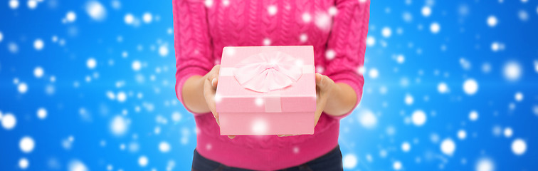 Image showing close up of woman in pink sweater holding gift box