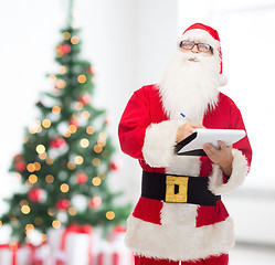 Image showing man in costume of santa claus with notepad