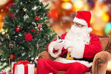 Image showing santa claus with smartphone and christmas tree