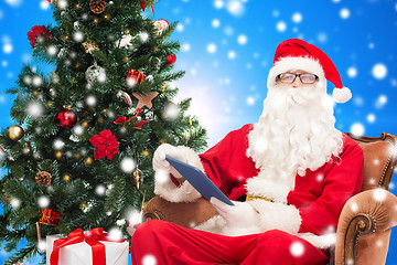 Image showing man in costume of santa claus with tablet pc