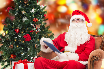 Image showing man in costume of santa claus with tablet pc