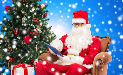 Image showing man in costume of santa claus with tablet pc