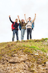 Image showing group of smiling friends with backpacks hiking