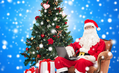 Image showing man in costume of santa claus with laptop