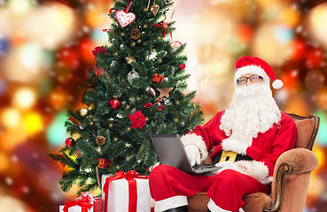 Image showing man in costume of santa claus with laptop